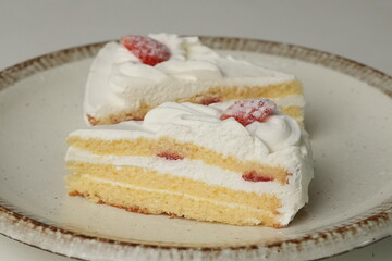 Two Japanese strawberry shortcakes on a stylish large plate on a white table