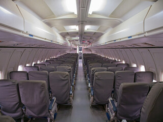 View of empty passenger seating area of an old 737-200 airplane from the back of the plane