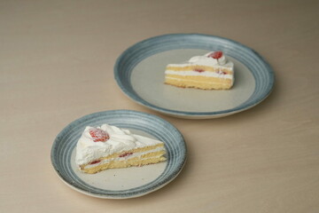Japanese strawberry shortcake on each stylish large and small plate on a wooden table