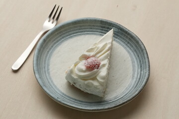 Japanese strawberry shortcake and fork on each stylish large and small plate on a wooden table