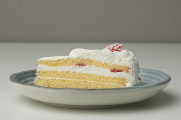 One small Japanese strawberry shortcake on a stylish Japanese plate on a white table