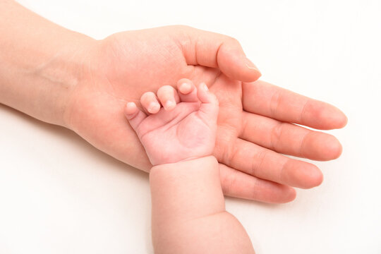 赤ちゃんの手を優しく握るママの手