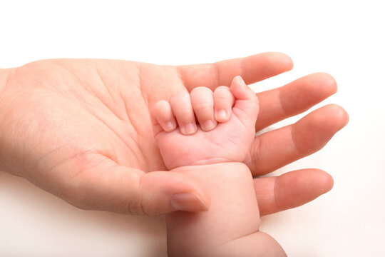 赤ちゃんの手を優しく握るママの手