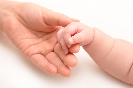 赤ちゃんの手を優しく握るママの手