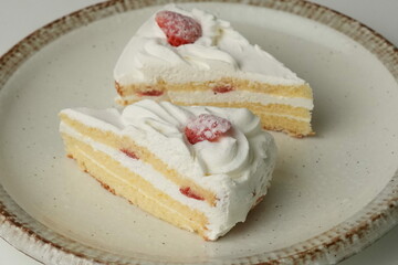 Two Japanese strawberry shortcakes on a stylish large plate on a white table