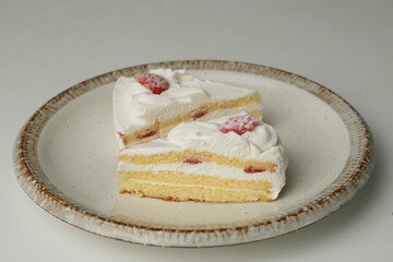Two Japanese strawberry shortcakes on a stylish large plate on a white table