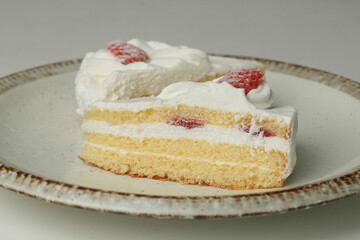 Two Japanese strawberry shortcakes on a stylish large plate on a white table