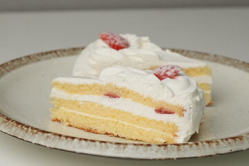 Two Japanese strawberry shortcakes on a stylish large plate on a white table