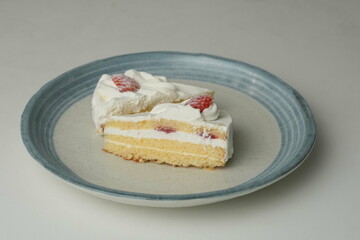 Two Japanese strawberry shortcakes on a stylish large plate on a white table