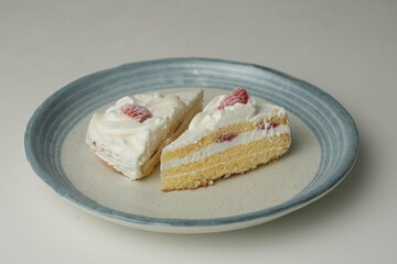 Two Japanese strawberry shortcakes on a stylish large plate on a white table