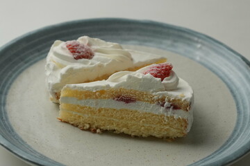 Two Japanese strawberry shortcakes on a stylish large plate on a white table
