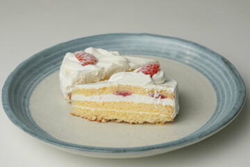 Two Japanese strawberry shortcakes on a stylish large plate on a white table