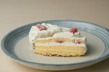 Two Japanese strawberry shortcakes on a stylish large plate on a wooden table
