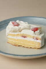 Two Japanese strawberry shortcakes on a stylish large plate on a wooden table