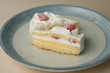 Two Japanese strawberry shortcakes on a stylish large plate on a wooden table