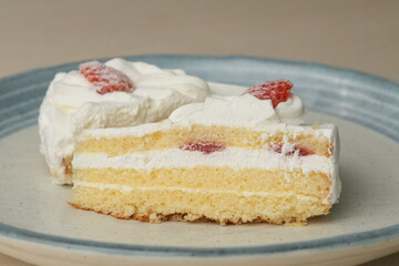 Two Japanese strawberry shortcakes on a stylish large plate on a wooden table