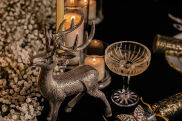 Holiday table with champagne, wine glass and New Year decorations in a cozy dinner