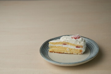 Japanese strawberry shortcake on each stylish large and small plate on a wooden table