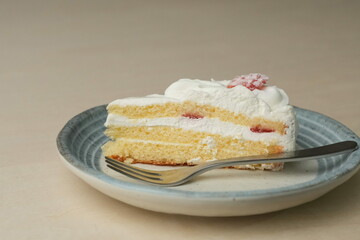 Japanese strawberry shortcake and fork on each stylish large and small plate on a wooden table