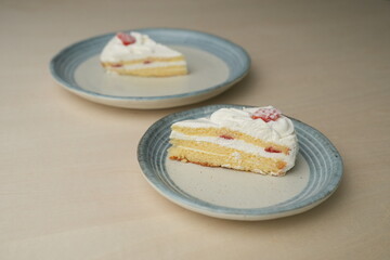 Japanese strawberry shortcake on each stylish large and small plate on a wooden table