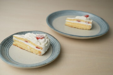 Japanese strawberry shortcake on each stylish large and small plate on a wooden table