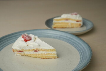 Japanese strawberry shortcake on each stylish large and small plate on a wooden table