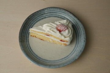 Japanese strawberry shortcake on a stylish large plate on a wooden table