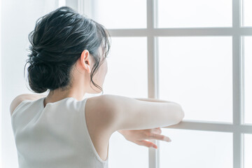 家で退屈・暇・憂鬱・無気力な気分で過ごす女性（生理痛・体調不良）
