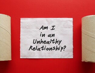 Toilet paper on red background with text written Am I in an Unhealthy Relationship? - means...
