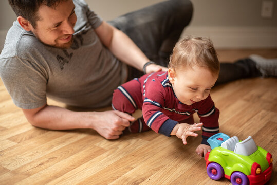 Baby plays with toy car with his dad