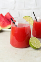 Delicious watermelon drink in glasses and fresh fruits on light table