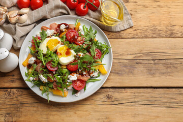 Tasty salad with arugula, egg, cheese and vegetables on wooden table, flat lay. Space for text