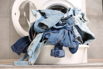 Washing machine and laundry basket with dirty denim clothes indoors