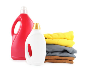 Laundry detergent in bottles and clothes isolated on white