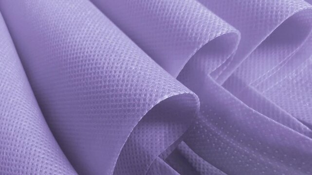 light purple polypropylene bag. non-woven fabric with wavy pleats. pile of environmentally friendly bag materials. spunbond bag