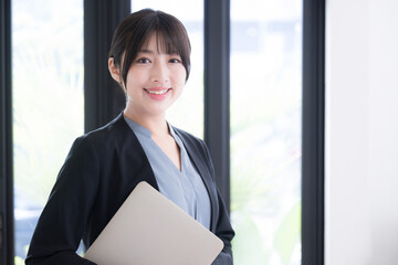 A young woman with a computer in her office, a business scene camera view of a young woman changing...