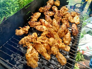 Barbecue grills at barbecue party in holiday. BBQ with chicken. Delicious fried cooked food.