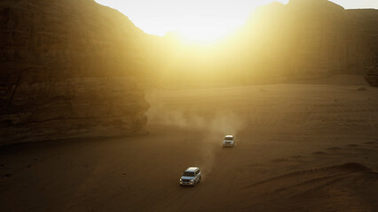 Vans driving through Saudi Arabian desert near sunset - high shot