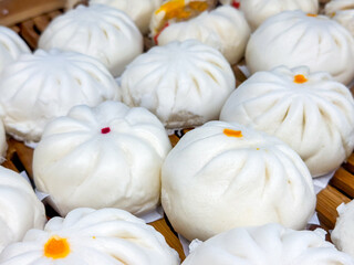 Steamed bun stuffed with minced pork on bamboo basket with black background