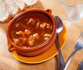 Plate contains pieces of tripe stewed in watering - stomach of cattle. Dish of Russian cuisine is made from giblets of cattle with spices and decorated with herbs