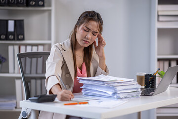 Obraz premium Business woman, anxiety and documents in office, feeling tired and stressed from working on laptop at the office, Angered, furious, crazy,mad millennial,Depression, overworked, failure,