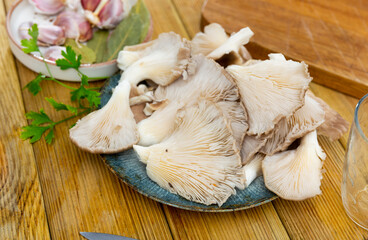 Raw oyster mushrooms served with parsley at table
