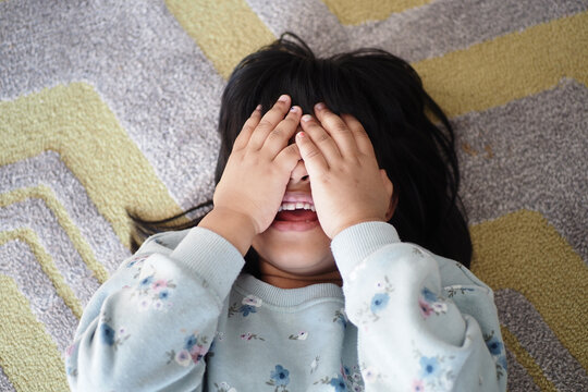 A delighted child is joyfully playing hide and seek, filled with laughter and excitement