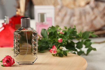 Bottle of men's perfume with roses on wooden stand