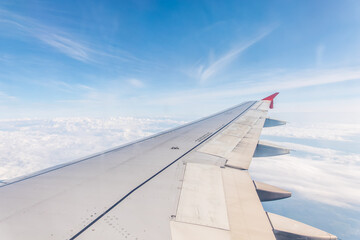 Obraz premium View from the airplane window at a beautiful cloudy sky and the airplane wing