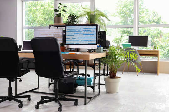 Interior of programmer's office with desks and plants