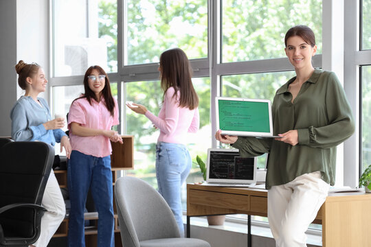 Female programmer with laptop in office