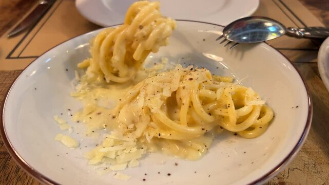 Eating traditional Italian creamy cacio e pepe spaghetti dish, delicious fresh pasta, 4K shot