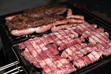 Asado barbecue over grill, being cooked, chorizo