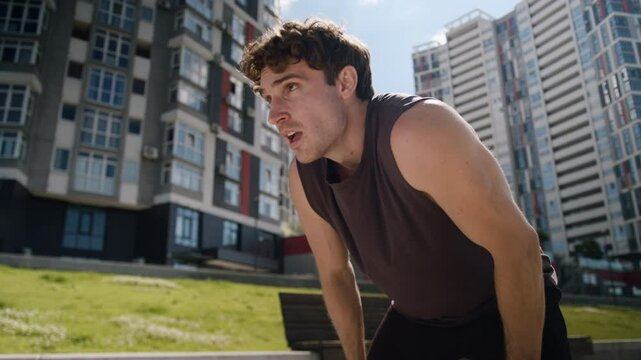 Tired Caucasian man male guy athlete sportsman sport running runner jogger training workout wipe sweat forehead activity city stop pause break exhausted exercise outdoors fitness fatigued jogging hard
